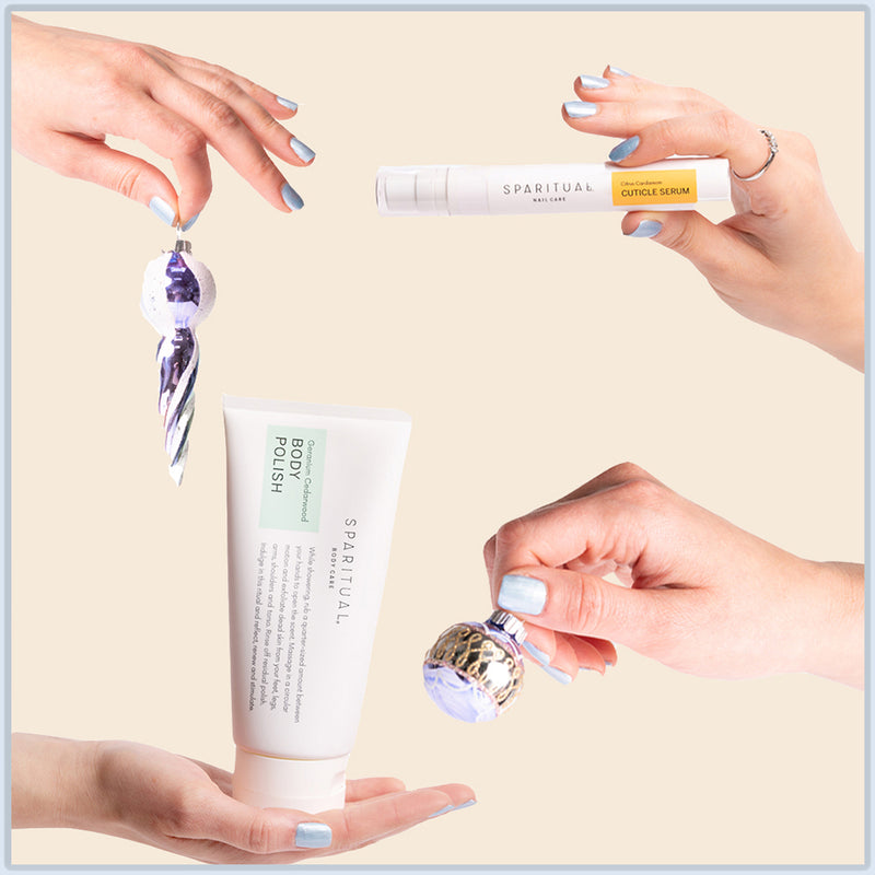 Holiday-themed image with SPARITUAL cuticle serum and body polish held in hands. Vegan, slow beauty products for healthy nails and skin care; giftable skincare sets.